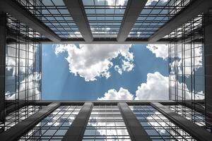 Modern Architectural Design Reflecting Blue Sky and Clouds in Urban Setting photo