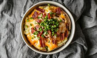 A bowl of food with bacon and onions on top photo