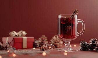 A glass of red wine with a cinnamon stick in it is on a table next to a red box photo