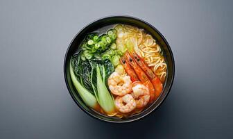 A bowl of soup with shrimp and vegetables photo