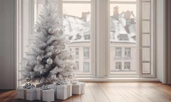 A white Christmas tree with a lot of ornaments sits in front of a window photo