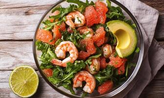 A bowl of shrimp and avocado salad with a lime wedge on the side photo