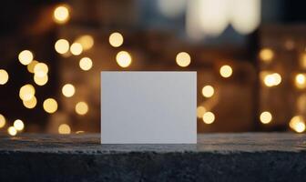 A white card is sitting on a table in front of a lighted background photo