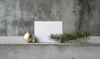 A white card with a gold ornament and a pine tree branch on top of it photo