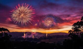 A fireworks display is lit up in the sky, with the sun setting in the background photo