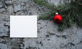 A white card with a red ornament hanging from a tree branch photo