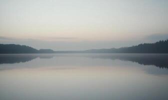 A calm lake with a cloudy sky in the background photo