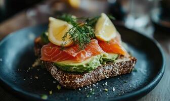 A plate of food with a sandwich and a lemon wedge on top photo