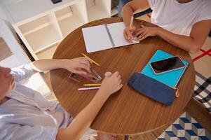 Students collaborating on a project at a wooden round table photo