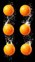 A set of oranges being splashed with water photo