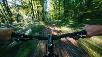 POV perspective of a cyclist with hand on handlebars riding through a forest at speed photo
