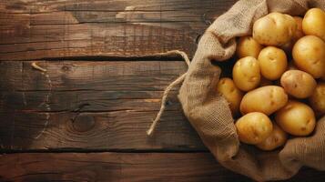 Potatoes in a sack on a wooden table photo