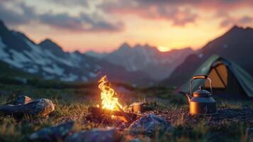 Camp fire and tea pot, tent and mountains in the background at sunset. Travel concept and Hobbies photo