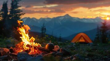 Camp fire and tea pot, tent and mountains in the background at sunset. Travel concept and Hobbies photo