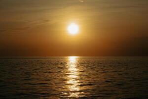 Sunset over the sea. The sun is reflected in the water. photo