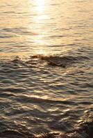 Sunset on the sea with waves and reflection in the water photo