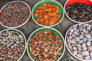 A variety of Fresh edible oysters, clams and scallops at the local market in Nha Trang, Vietnam. photo