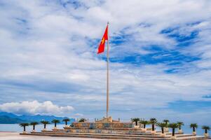 The flag of Vietnam on the background of the sky and coastline on the central square of Nha Trang city. photo