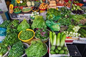 Various vegetables and herbs on the market in wicker baskets. photo