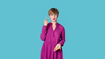 A woman dressed in casual clothes holds a silicone menstrual cup and a tampon in her hands, highlighted on a simple blue background. photo