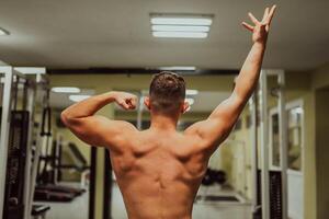 Image of a man bodybuilder from a back at gym. photo