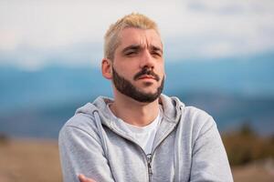 Portrait of a bearded thoughtful man outside. photo