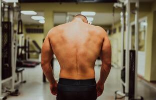 Image of a man bodybuilder from a back at gym. photo
