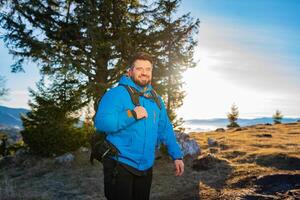A happy man backpacker trail hiking on the mountain forest adventure travel active lifestyle. photo