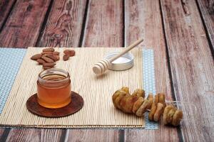 Bowl with a flat oat meal with a fresh honey and a fruit on the wooden table background. photo