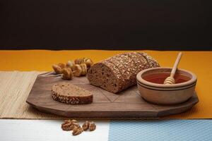 whole grain bread and fruit and walnut and honey on the wooden table isolated on black background. photo
