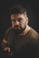 Portrait of a middle age man using a phone isolated on the black background. photo