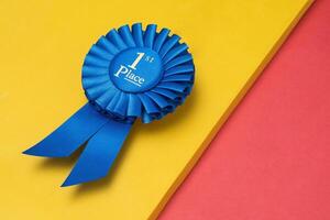 Rosette first place for the achievement and success of the winner on an illuminating background photo