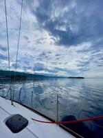 a boat is sailing in the sea with a cloudy sky in the background photo