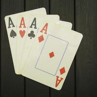 Four aces of spades on a wooden table photo