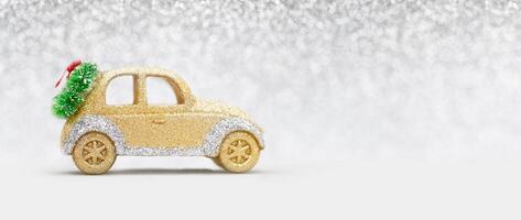 Christmas greeting card. Golden glow toy car with wreath on light gray blurred bokeh background. New Year photo