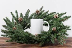Christmas mockup one white empty tea mug on a white table and branches of a Christmas tree wreath. photo
