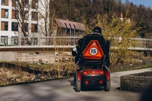 Germany, Schwabisch Gmund, March 9,2024.Person in a specialized mobility scooter for disabilities, driving through a park setting photo