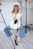 A girl in a photography studio, skillfully adjusting her camera settings while preparing for a creative photoshoot photo
