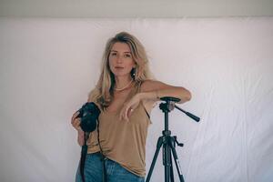 A female photographer confidently posing with her camera in a professional studio, ready to capture stunning images photo