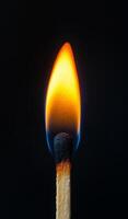 A matchstick is lit and the flame is yellow. Concept of warmth and comfort, as well as a reminder of the potential danger of fire photo