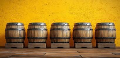 Five barrels of wood are lined up against a yellow wall. The barrels are all different sizes and are made of wood. The scene has a rustic and cozy feel to it photo