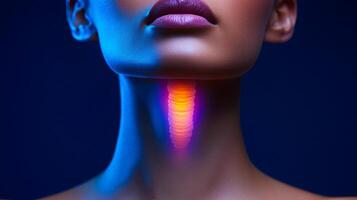 A woman's neck is glowing in the dark blue background. The neck is the main focus of the image, and the glowing effect adds a sense of mystery and intrigue to the scene photo