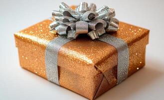 A shiny gold and silver gift box with a bow on top. The box is decorated with glitter and has a shiny appearance photo