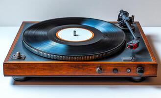 A vintage record player with a black record on it sits on a wooden surface. The record player is made of wood and has a black and white record photo