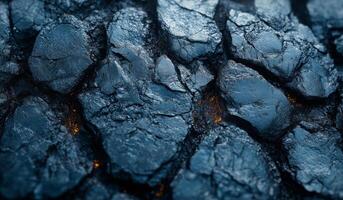 The image is of a rocky surface with a blue color. The rocks are rough and jagged, and there are some small holes in them. Scene is rugged and wild, with a sense of untamed nature photo