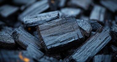A pile of black wood with a lot of cracks and splinters. The wood is black and rough, and it looks like it has been used for a long time photo