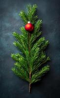 A Christmas tree with a red ornament on top. The tree is surrounded by a dark background. Concept of warmth and holiday cheer photo