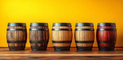 A row of wooden barrels with different colors and sizes. The barrels are arranged on a wooden shelf photo