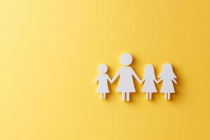 A woman holding hands with three children. The image is on a yellow background. Scene is warm and loving photo