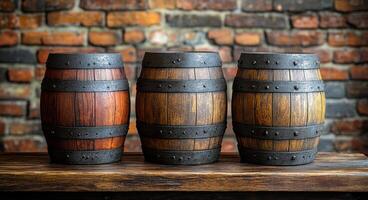 Three wooden barrels are lined up on a wooden table. The barrels are of different sizes and colors, with one being brown and the other two being black. The scene gives off a rustic and vintage vibe photo